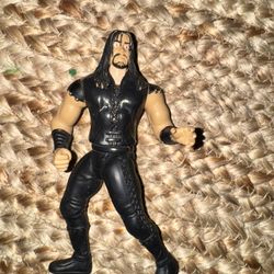 The Vintage 1997 WWE THE UNDERTAKER Jakks Pacific Slammers Wrestling Action Figure is a 6-inch plastic collectible representing the iconic WWE charact