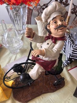 Whimsical resin chef figurine riding a bike