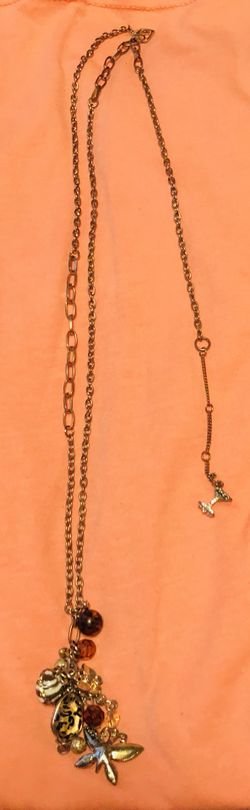 Long gold necklace with lots of small charms. Never worn