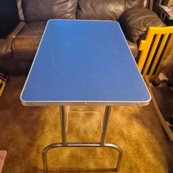 Medium Sized Metal folding Table. Very strong  20 by 32. Height 29. Hard rubber blue top. Folds easy. 