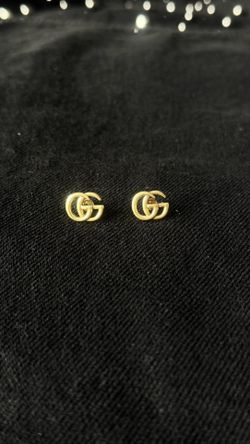 New gold-tone stud earrings, minimalist interlocking design.