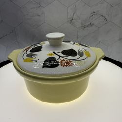This is a vintage Mid-Century Modern Northington USA pottery lidded casserole dish with a yellow base and a lid featuring a grey, brown, and yellow fl