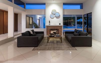 Two large gray linen sofas, area rug, and vintage brass/glass coffee table