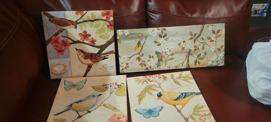 four bird-themed wall art panels, typically printed on canvas and stretched over wooden frames. These pieces often feature a mix of birds and butterfl