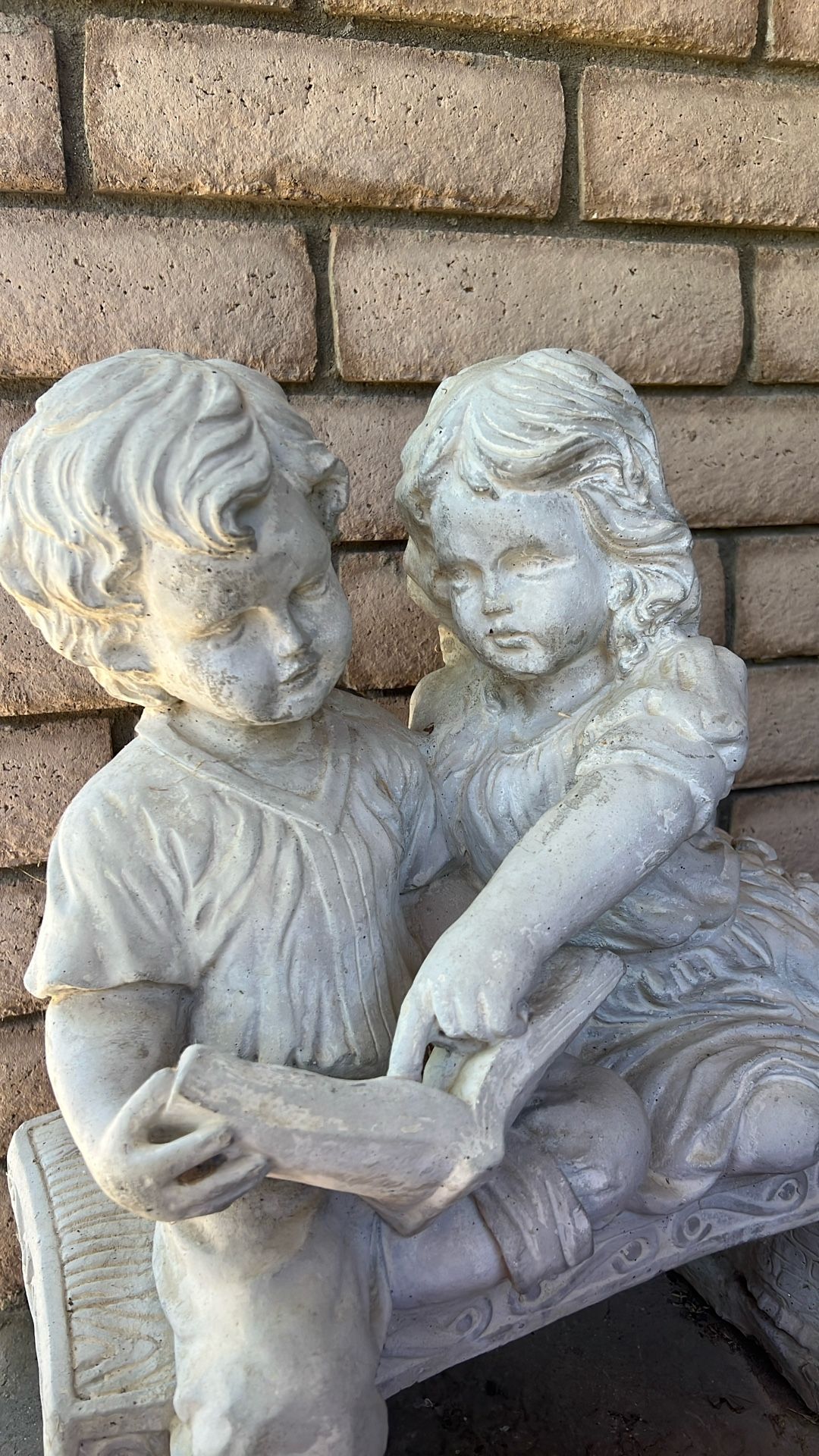 Statue Of Little Girl And Boy Reading On Bench