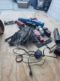vintage Lionel O/O-27 gauge train collection, featuring a blue Missouri Pacific 219 diesel locomotive, a large bundle of tubular metal tracks, and ass
