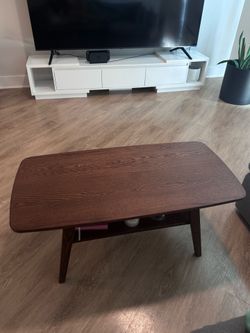 Minimalist coffee table with storage. In excellent condition with storage underneath. Cool-toned walnut finish.