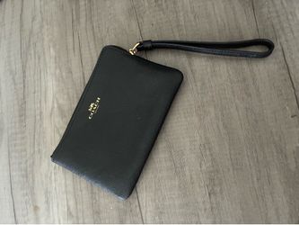 Black Coach wristlet wallet with zipper closure and wrist strap