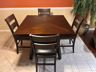 Dining table with high chairs goes from a square to a circle for smaller to bigger.