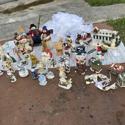 collection of vintage holiday and Christmas decorative figurines, including resin and ceramic snowmen, Santa Claus figures, angels, tiny houses, a gol