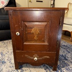 This is a vintage wooden nightstand or end table with a drawer and a cabinet.