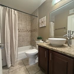 Beautiful cherry wood bathroom vanity with granite top and sink bowl and a faucet
