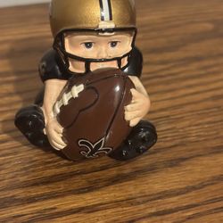 vintage New Orleans Saints bobblehead figure depicting a young football player in a seated position
