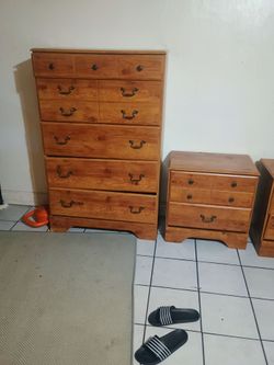 Solid pine bedroom set includes one tall dresser and two matching nightstands.