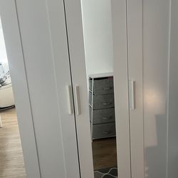 White wooden  wardrobe closet with long mirror and storage cabnit