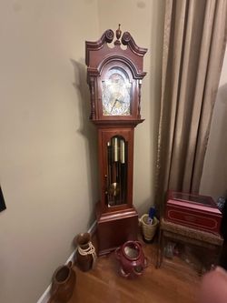 traditional wooden grandfather clock features a broken-pediment swan neck crest with a center finial