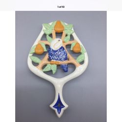 Vintage 1970 Signed Artisan White Ornate Ceramic TRIVET Blue Parrot Orange Fruit Jungles    It measures 8.5"x 6".    Signed and dated 1970.  Very uniq
