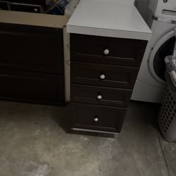 Available dark brown kitchen cabinets. Has a few base cabinets with drawers and doors. Also has a corner cabinet. Comes with silver knobs. Edges show 
