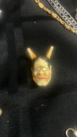 A a Japanese hyena mask it’s a charm or keychain. I’m not sure which, but on the backside of it it’s with the ladies with her legs open.