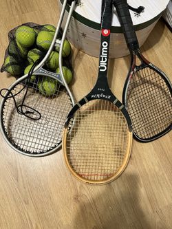 3 tennis rackets and tennis balls