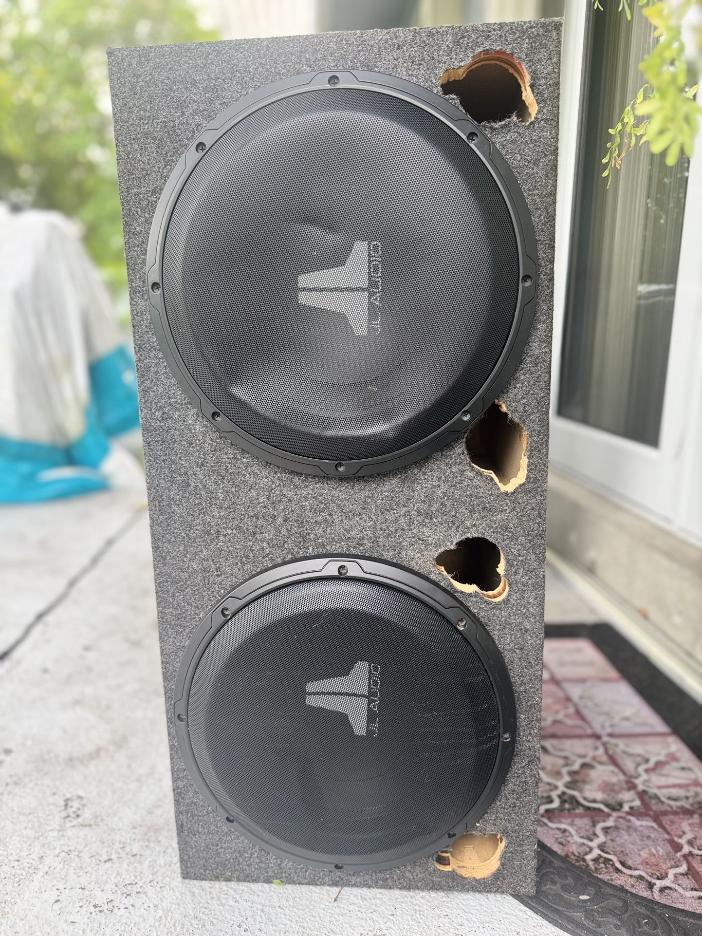 JL Audio en una rejilla de malla de acero, probablemente para un subwoofer. 