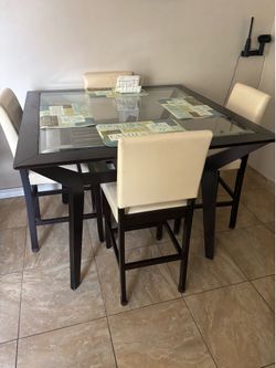 Beautiful counter-height dining set with tempered glass top and 4 matching upholstered chairs.