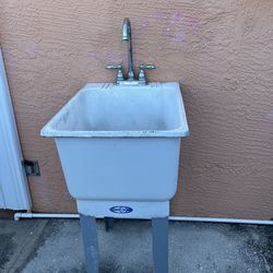 Plastic sink with metal legs and faucets. It needs a fresh coat of paint but is in good condition. Height: 33 inches; Width: 23 inches; Length: 17 1/2