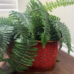 Large artificial fern housed in a decorative red planter in very good condition