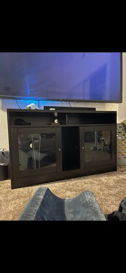 Dark Wood Entertainment Center With Two Cabinets With Glass Doors.
