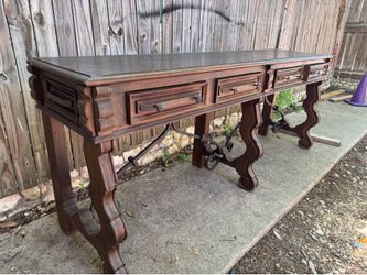 Jason Scott Spanish Prison console table features a dark wood finish and decorative iron