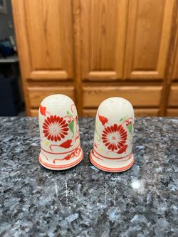 Vintage ceramic salt and pepper shakers feature a handpainted red floral design with flared bellshaped bases.  Size approximately 2 1/2 inches tall.  