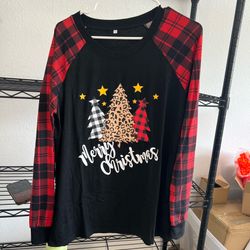 Festive long sleeve raglan shirt with a black body and red plaid sleeves. It is made of a jersey knit material. The front has a graphic of three Chris