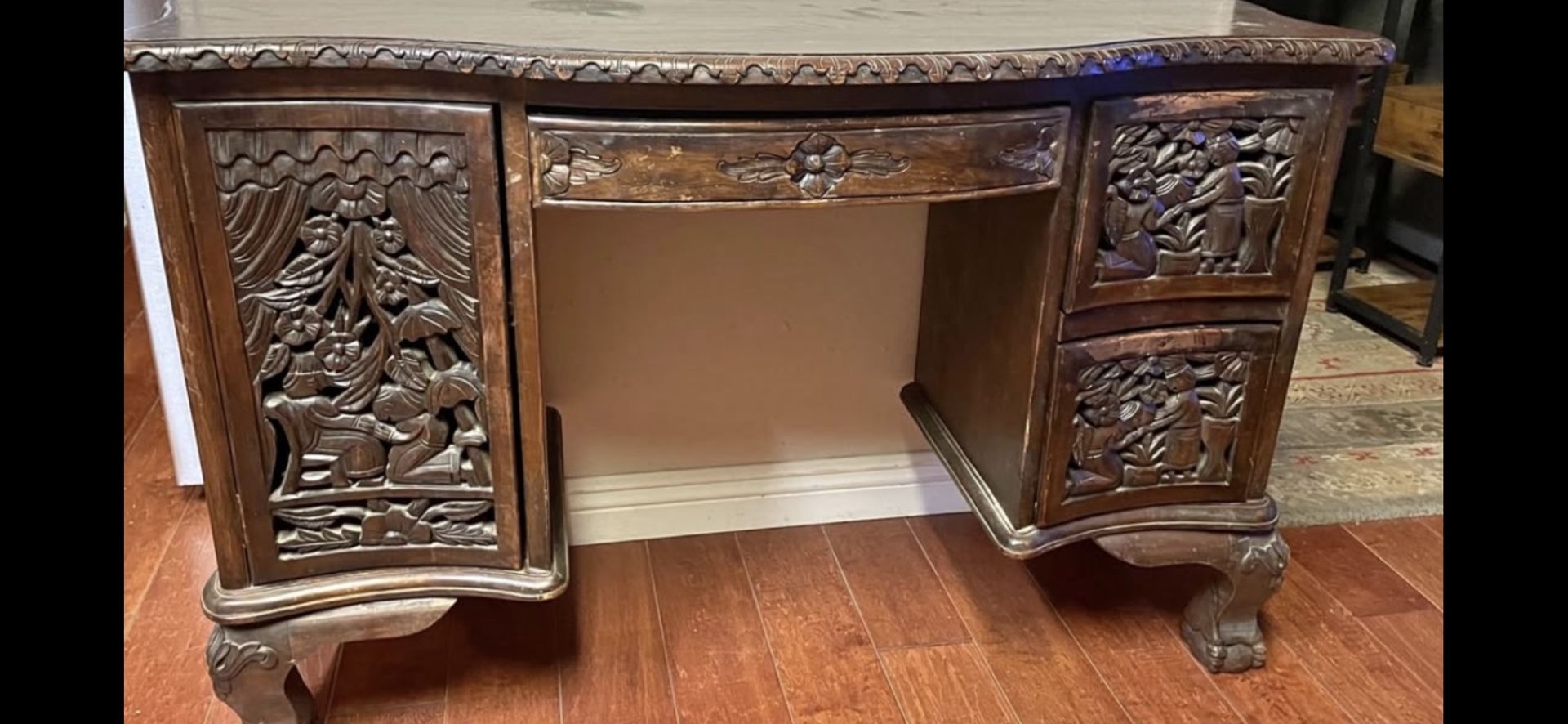 Antique Southeast Asian carved rosewood desk with intricate figural and floral motifs.