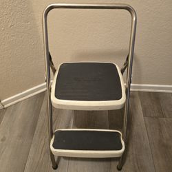 This is a vintage Cosco 2-step folding step stool in cream/white metal