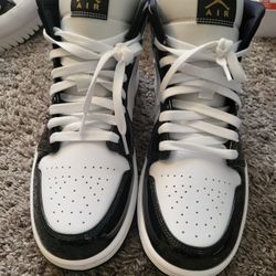 Nike Air Jordan 1 Mid Patent SE shoes in a black and gold colorway