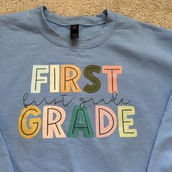 First Grade Teacher Sweatshirt. Blue. Pastel. Size Medium.