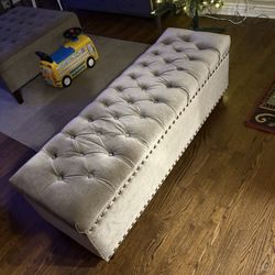 tufted upholstered storage bench featuring nailhead trim details and velvet fabric upholstery. 