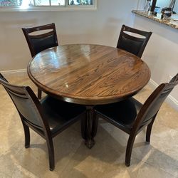 Selling a solid wood round dining table with 4 chairs included.