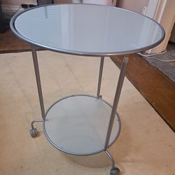 This IKEA Heimdal glass and metal rolling side table 