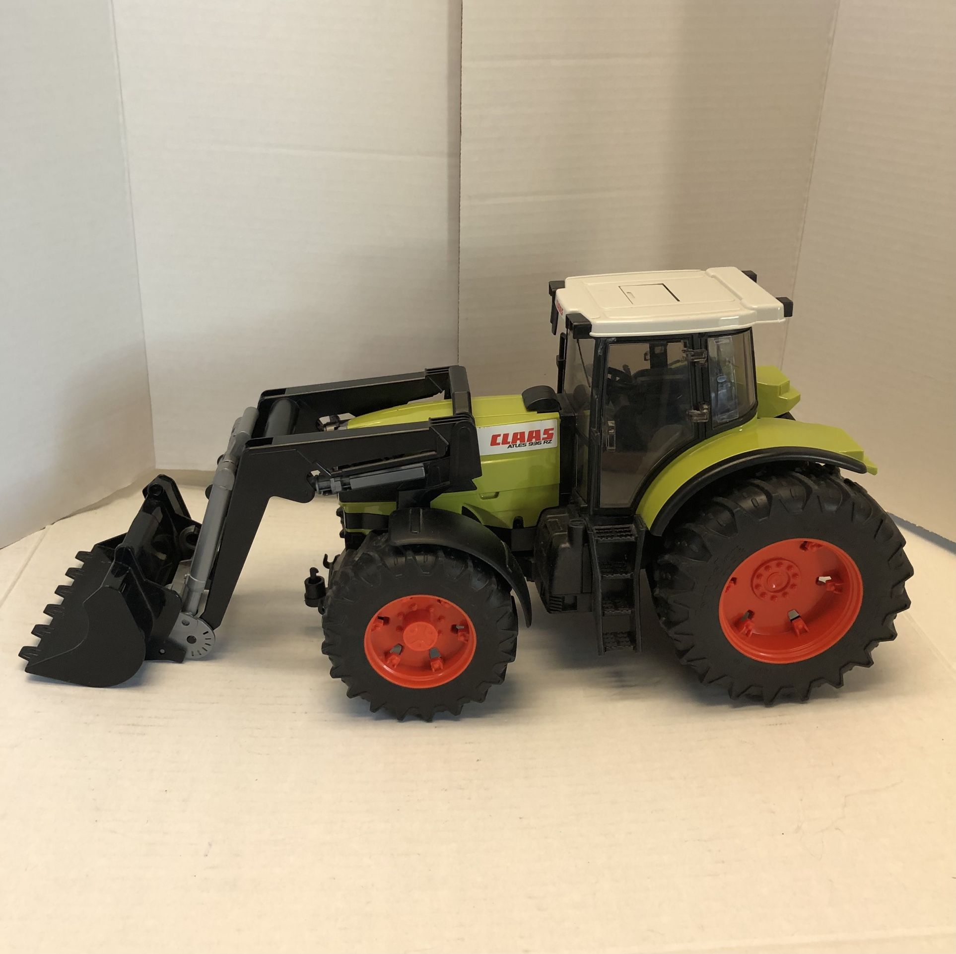 BRUDER retired toy model 1/16 Scale Claas Atles 936 RZ Tractor with Front End Loader - Pro Series Features include: • Opening engine hood and detaile