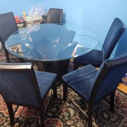 round glass table with four blue chairs used like new 