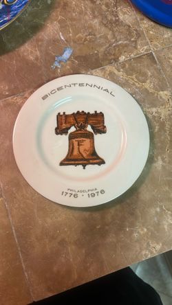 This is a vintage 1976 United States Bicentennial commemorative porcelain plate featuring the Liberty Bell.     