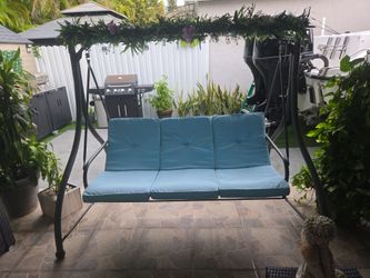 Columpio y sofa de patio con cojines color turqueza