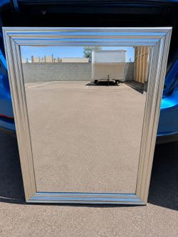 Large decorative wall mirror with silver frame.