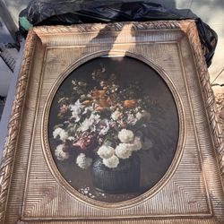 Oval floral still life oil painting in an ornate gilded frame.