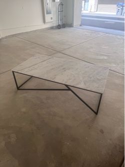 Modern Quartz Coffee Table – 63” x 31.5”  Beautiful modern coffee table featuring a heavy quartz stone top with natural gray veining and a sleek black