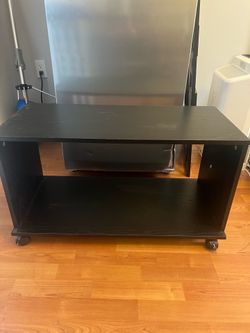 Small black TV stand with coasters / wheels