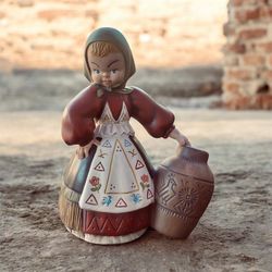 Mid-century hand-painted Eur-O-Con Ceramic FIgurine  of a woman in traditional European folk attire carrying a large earthenware jar.