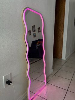 Wavy full-length mirror with pink LED light trim