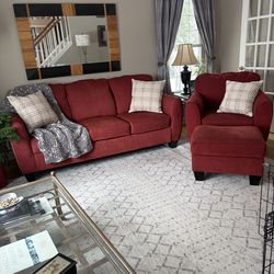 Red couch, matching chair and ottoman.